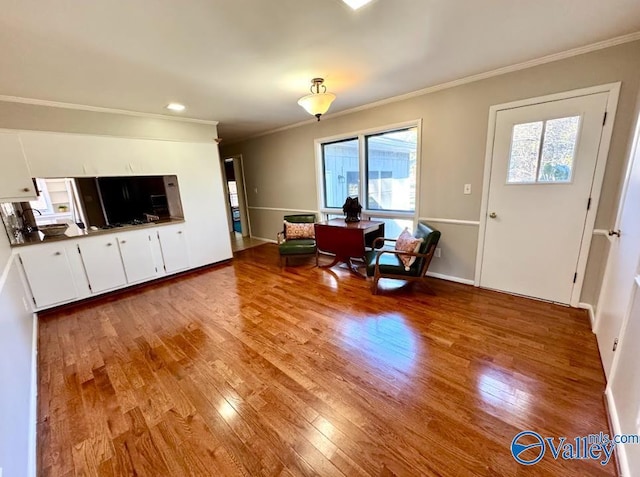 living room with ornamental molding and light hardwood / wood-style floors