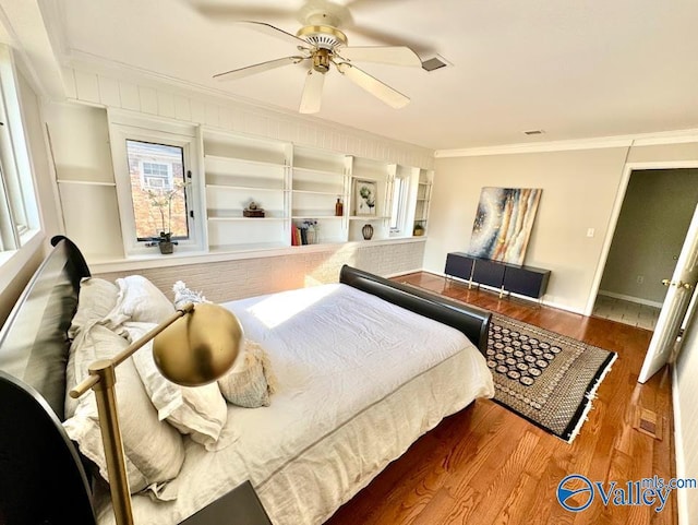 bedroom with crown molding, wood-type flooring, and ceiling fan