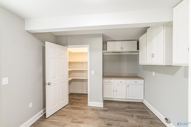 washroom featuring wood finished floors and baseboards