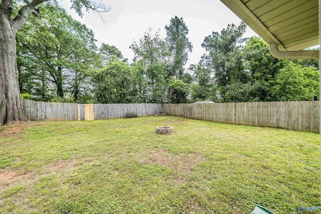 view of yard featuring a fire pit and a fenced backyard