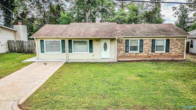 ranch-style house with a front lawn, brick siding, and fence