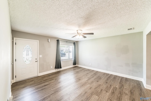 entrance foyer featuring a ceiling fan, baseboards, a textured ceiling, and wood finished floors