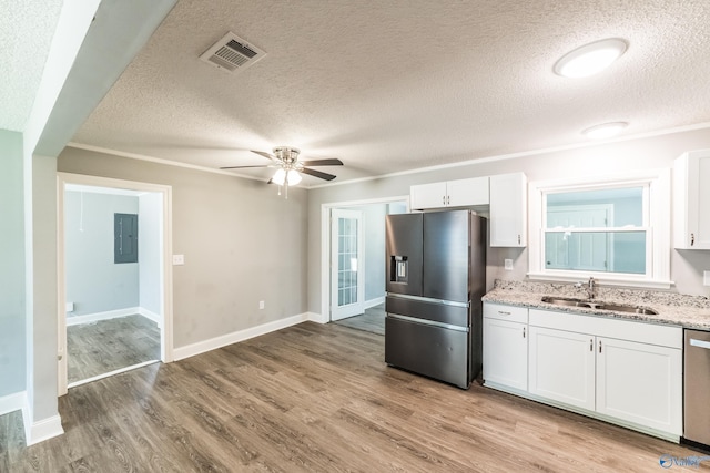 kitchen with a textured ceiling, stainless steel appliances, visible vents, and a sink