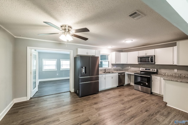 kitchen with a sink, white cabinets, a textured ceiling, visible vents, and appliances with stainless steel finishes