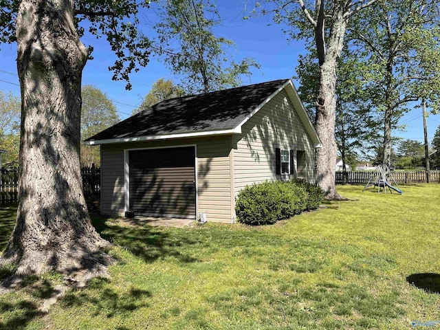 view of outbuilding with fence, an outbuilding, and a playground