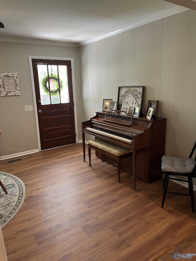 entrance foyer featuring ornamental molding, wood finished floors, and visible vents