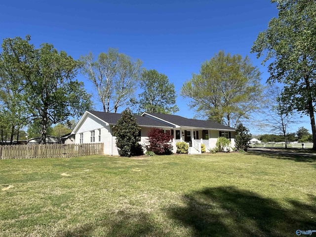 view of front of home featuring fence and a front lawn
