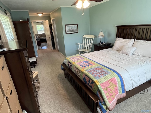 bedroom featuring ornamental molding, ceiling fan, and light carpet