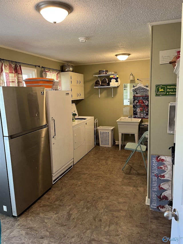 laundry room featuring washer and dryer and a textured ceiling