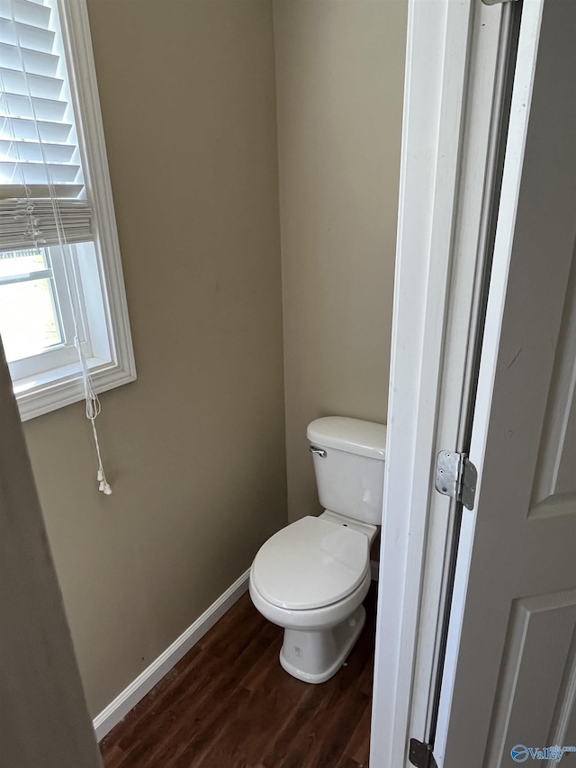 bathroom featuring toilet, baseboards, and wood finished floors
