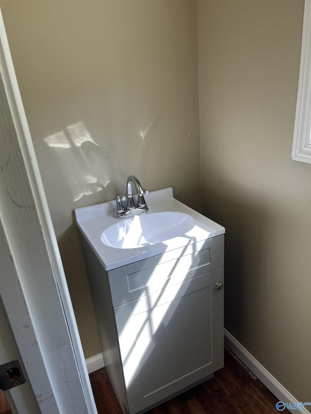 bathroom with baseboards, vanity, and wood finished floors