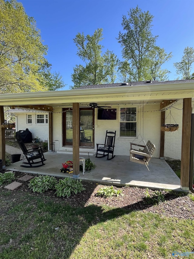rear view of house featuring a patio area and concrete block siding