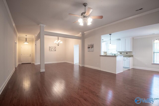 unfurnished living room with sink, dark hardwood / wood-style flooring, ceiling fan with notable chandelier, and ornamental molding