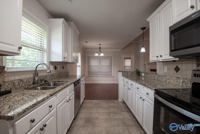 kitchen with hanging light fixtures, white cabinetry, sink, and appliances with stainless steel finishes