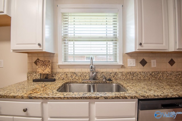 kitchen with backsplash, dishwasher, sink, and white cabinets