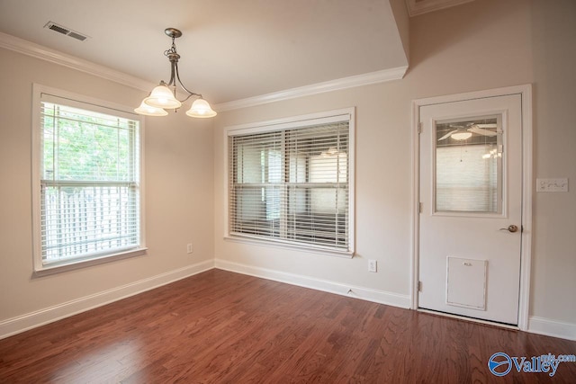 spare room featuring a notable chandelier, dark hardwood / wood-style flooring, and ornamental molding