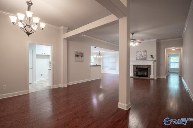 unfurnished living room featuring a fireplace, dark hardwood / wood-style flooring, ceiling fan with notable chandelier, and ornamental molding