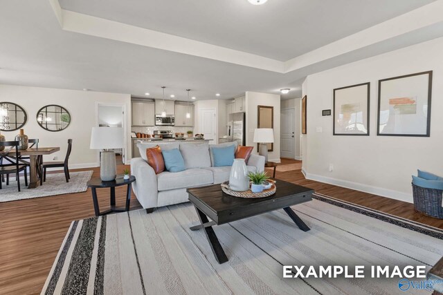 158 River Pointe Dr, New Market, AL 35761 - living room with baseboards, light wood-style floors, a raised ceiling, and recessed lighting