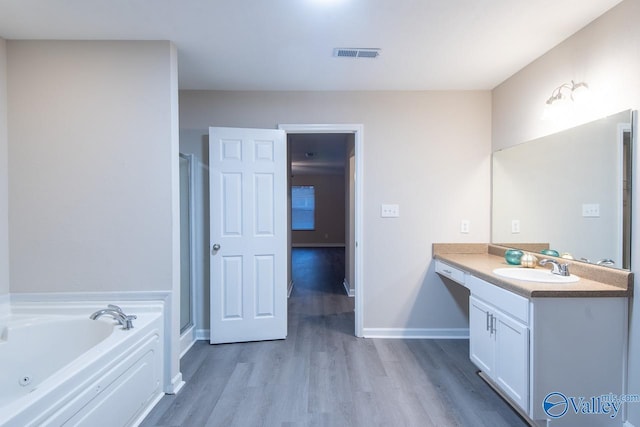 bathroom featuring hardwood / wood-style flooring, vanity, and shower with separate bathtub