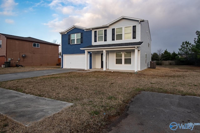 view of front of home featuring central AC unit, a garage, and a front lawn