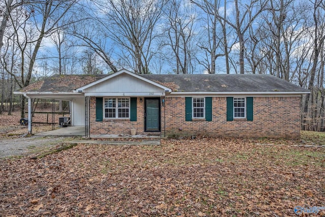 single story home with cooling unit and a carport