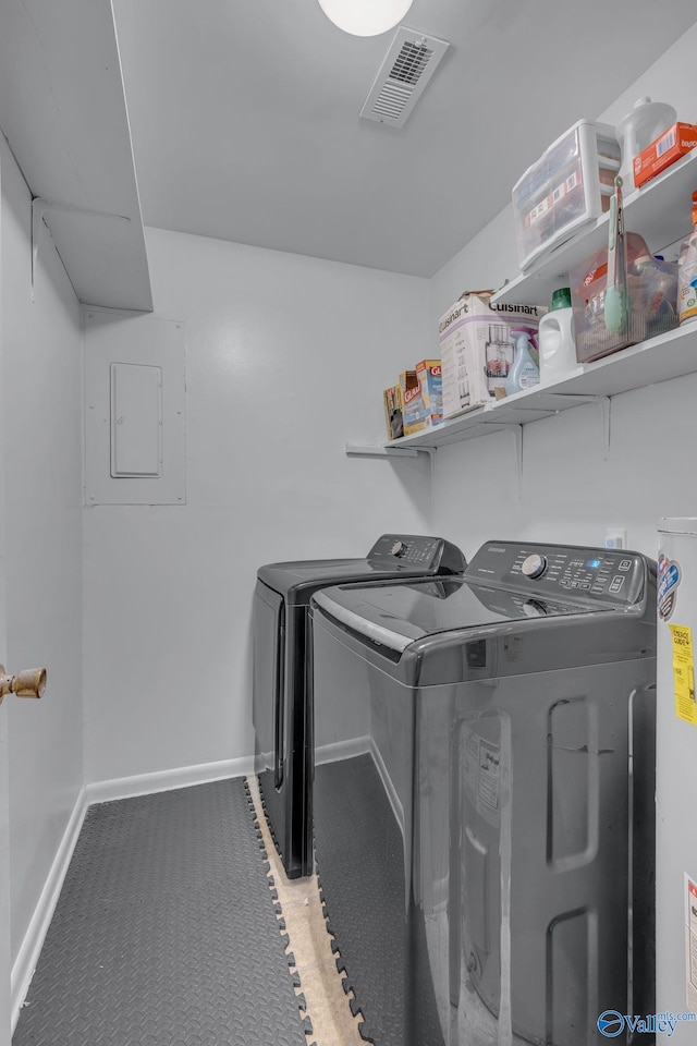 clothes washing area with separate washer and dryer, electric panel, and gas water heater