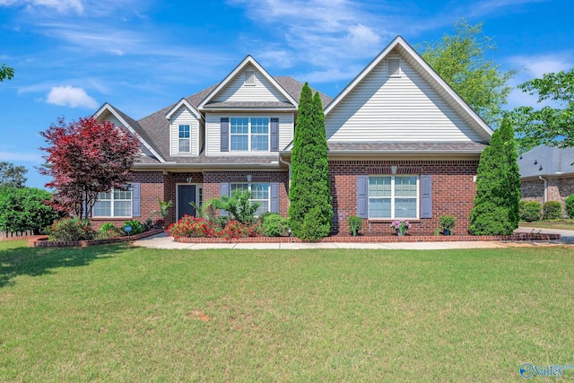 craftsman inspired home with roof with shingles, a front lawn, and brick siding