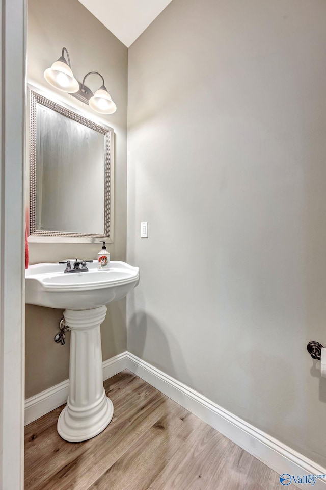 bathroom with wood finished floors and baseboards