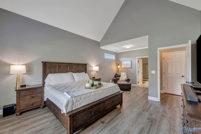 bedroom featuring light wood-style floors, baseboards, and high vaulted ceiling