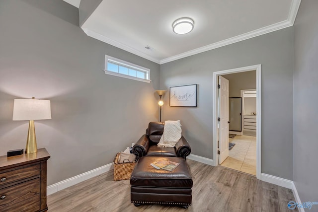 living area featuring baseboards, ornamental molding, visible vents, and wood finished floors