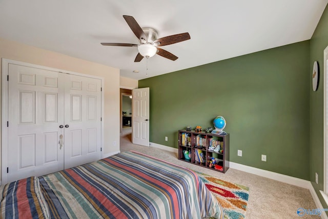 carpeted bedroom with baseboards, a closet, and a ceiling fan