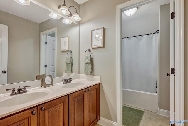 bathroom featuring baseboards, tile patterned floors, double vanity, and a sink
