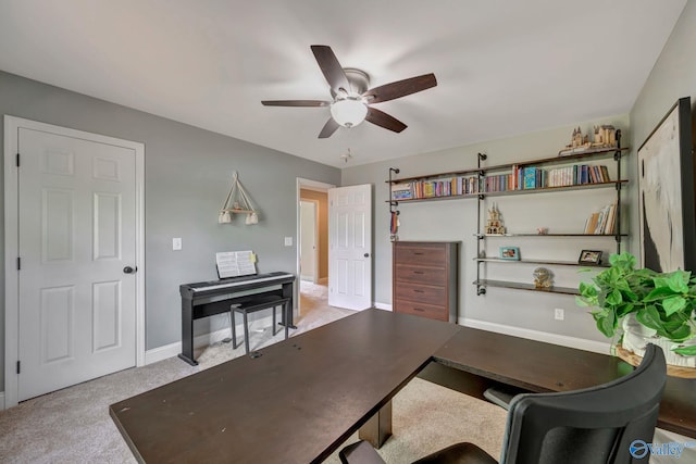 carpeted home office featuring a ceiling fan and baseboards