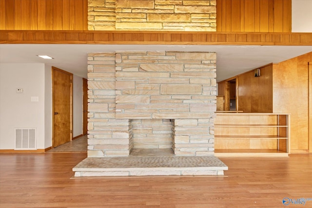 interior details featuring hardwood / wood-style flooring and wood walls