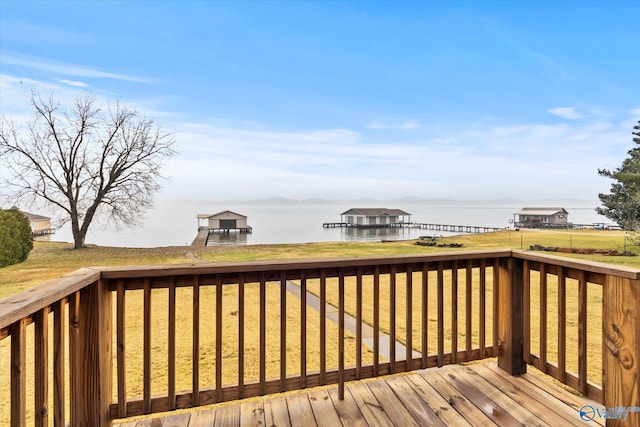 wooden deck featuring a lawn and a water view