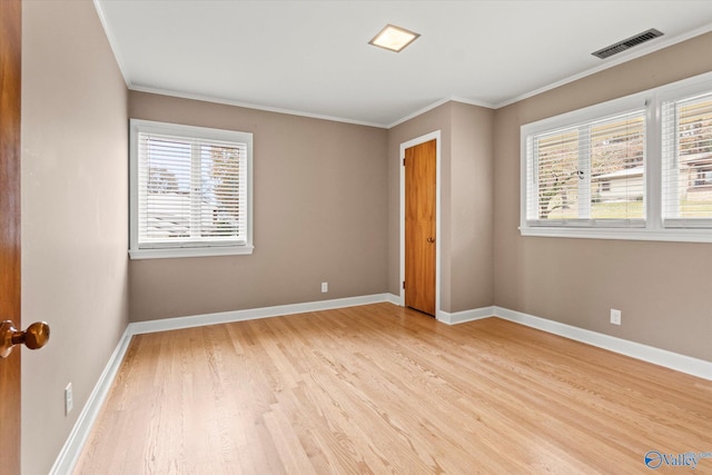 unfurnished bedroom with crown molding and light wood-type flooring