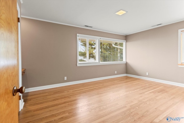 empty room with ornamental molding and light wood-type flooring