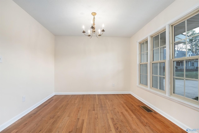 unfurnished room featuring light hardwood / wood-style flooring and a notable chandelier