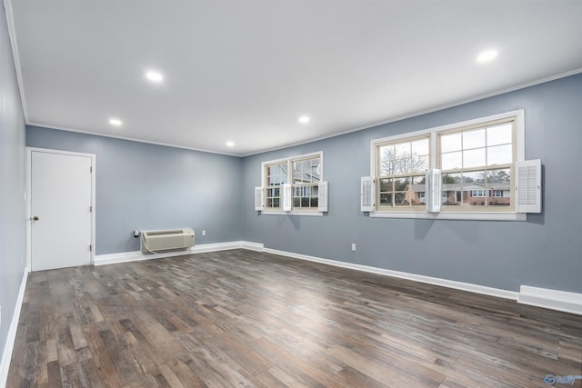 empty room featuring dark hardwood / wood-style flooring, a wall mounted air conditioner, and ornamental molding