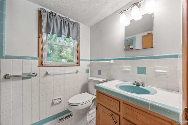 11303 Crestfield Dr, Huntsville, AL 35803 - bathroom with a textured ceiling, toilet, tile patterned floors, vanity, and tile walls