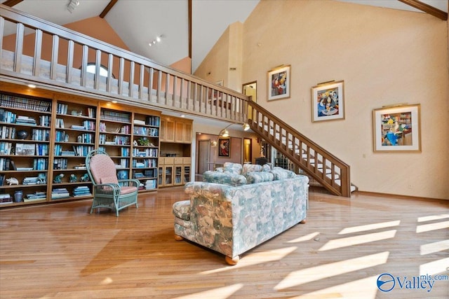 living room featuring light wood-type flooring and high vaulted ceiling