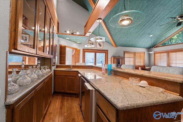 kitchen with light hardwood / wood-style flooring, decorative light fixtures, light stone counters, sink, and ceiling fan