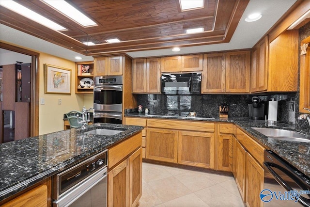 kitchen with black appliances, dark stone countertops, and sink