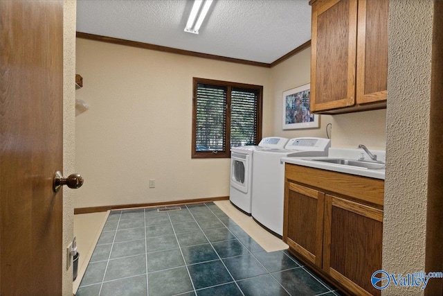 washroom featuring cabinets, a textured ceiling, washer and dryer, dark tile patterned floors, and sink