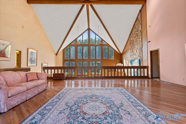 living area featuring beamed ceiling, high vaulted ceiling, and hardwood / wood-style floors