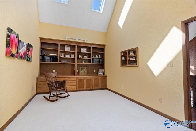 living area featuring vaulted ceiling with skylight and light carpet