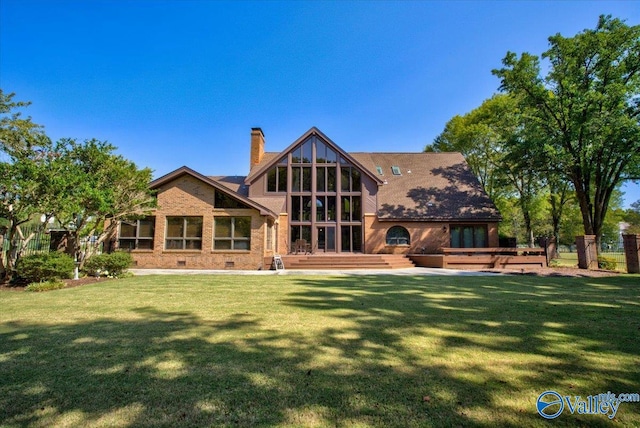 rear view of house featuring a yard and a wooden deck