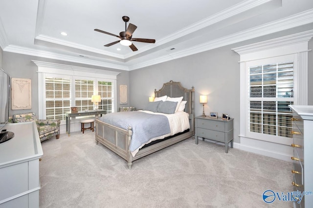 carpeted bedroom featuring visible vents, a ceiling fan, ornamental molding, and a raised ceiling