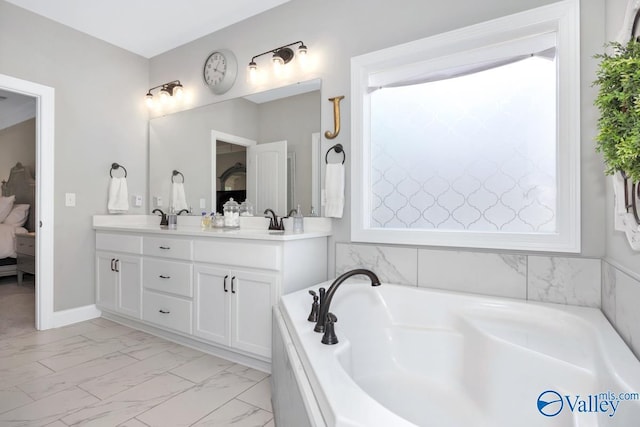 bathroom featuring marble finish floor, double vanity, a sink, ensuite bath, and a garden tub