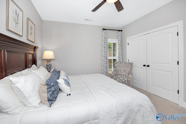 carpeted bedroom featuring a closet, a ceiling fan, and visible vents